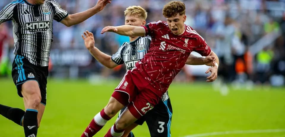 Newcastle player challenges Liverpool player for ball