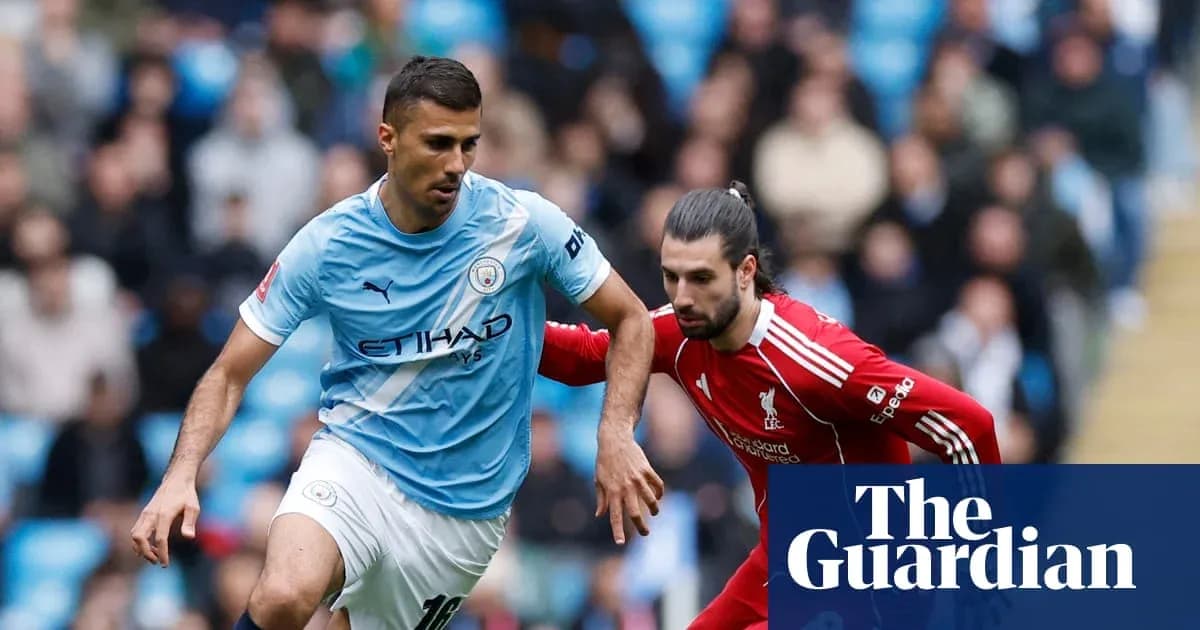 Manchester City player dribbling past Liverpool opponent