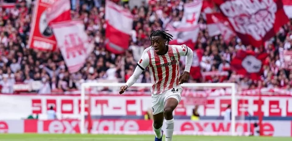 Player dribbling the ball with fans in background