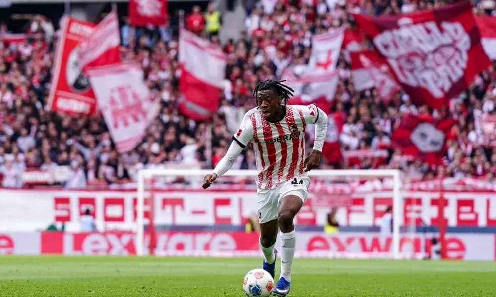 Player dribbling the ball with fans in background