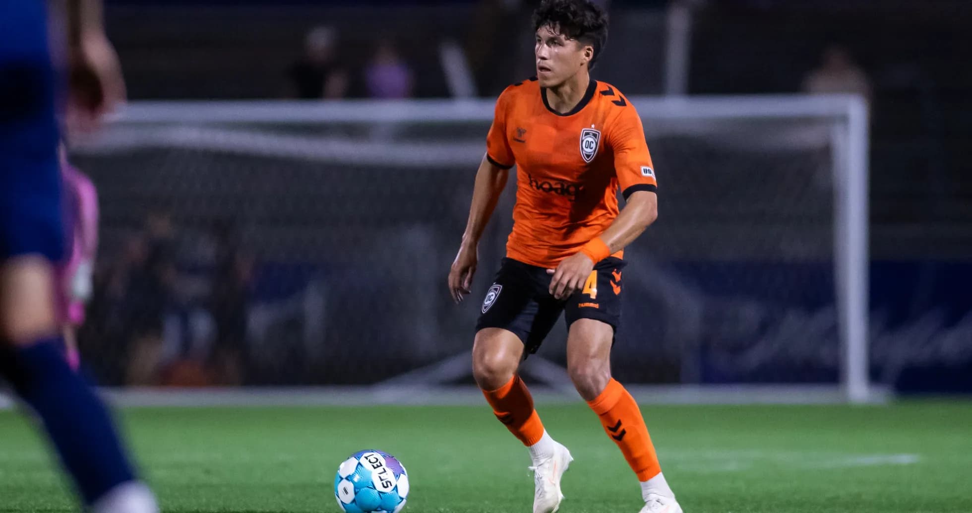 Player in orange kit controlling the ball