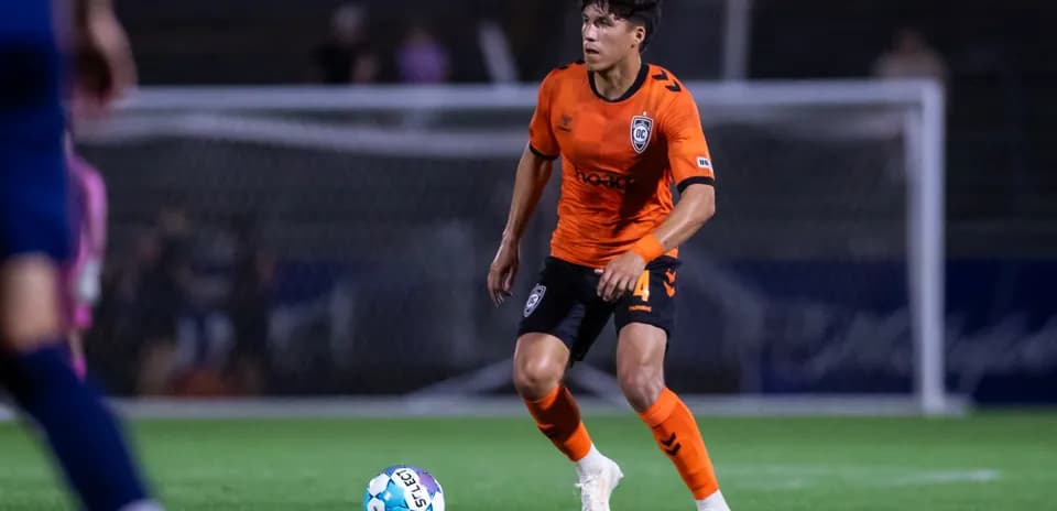 Player in orange kit controlling the ball