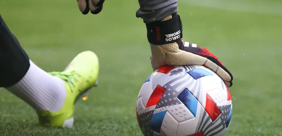 Goalkeeper placing ball on pitch before play
