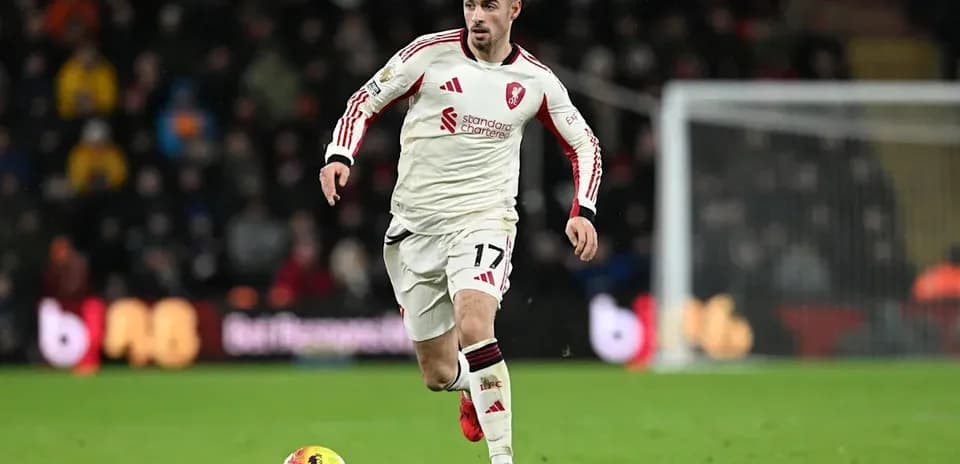 Player in white kit dribbling ball on field