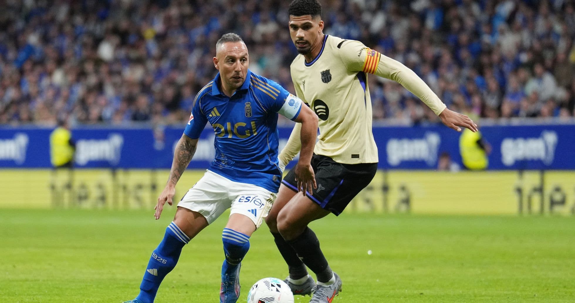 Oviedo player dribbling against Alaves opponent