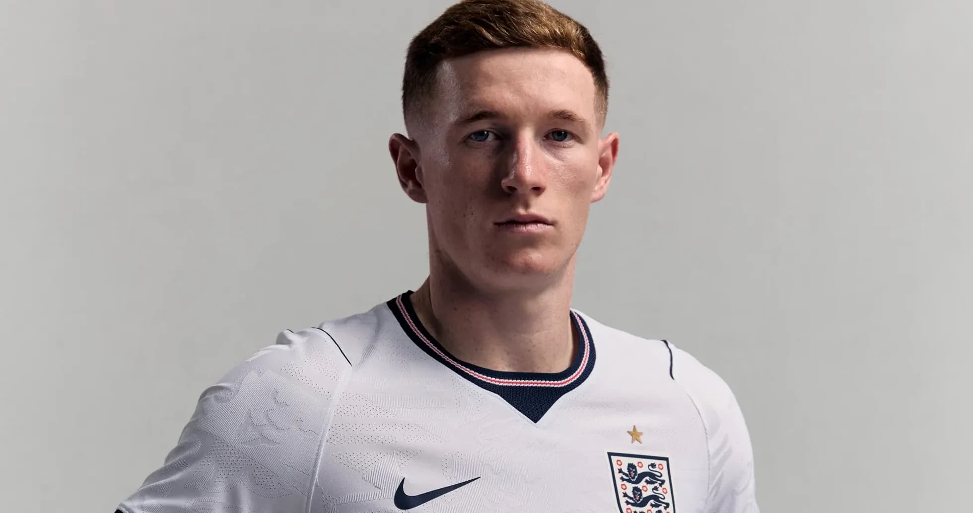 Player wearing England football kit, serious expression