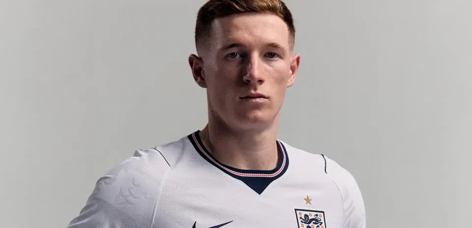 Player wearing England football kit, serious expression