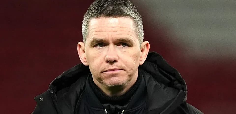 Coach in a black jacket during a match