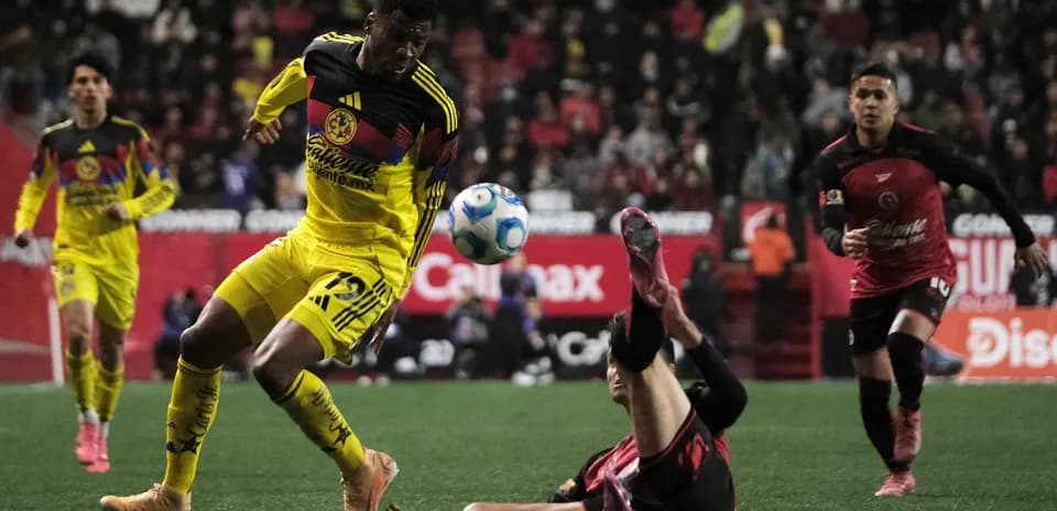 Club America player dribbling past Club Tijuana opponent