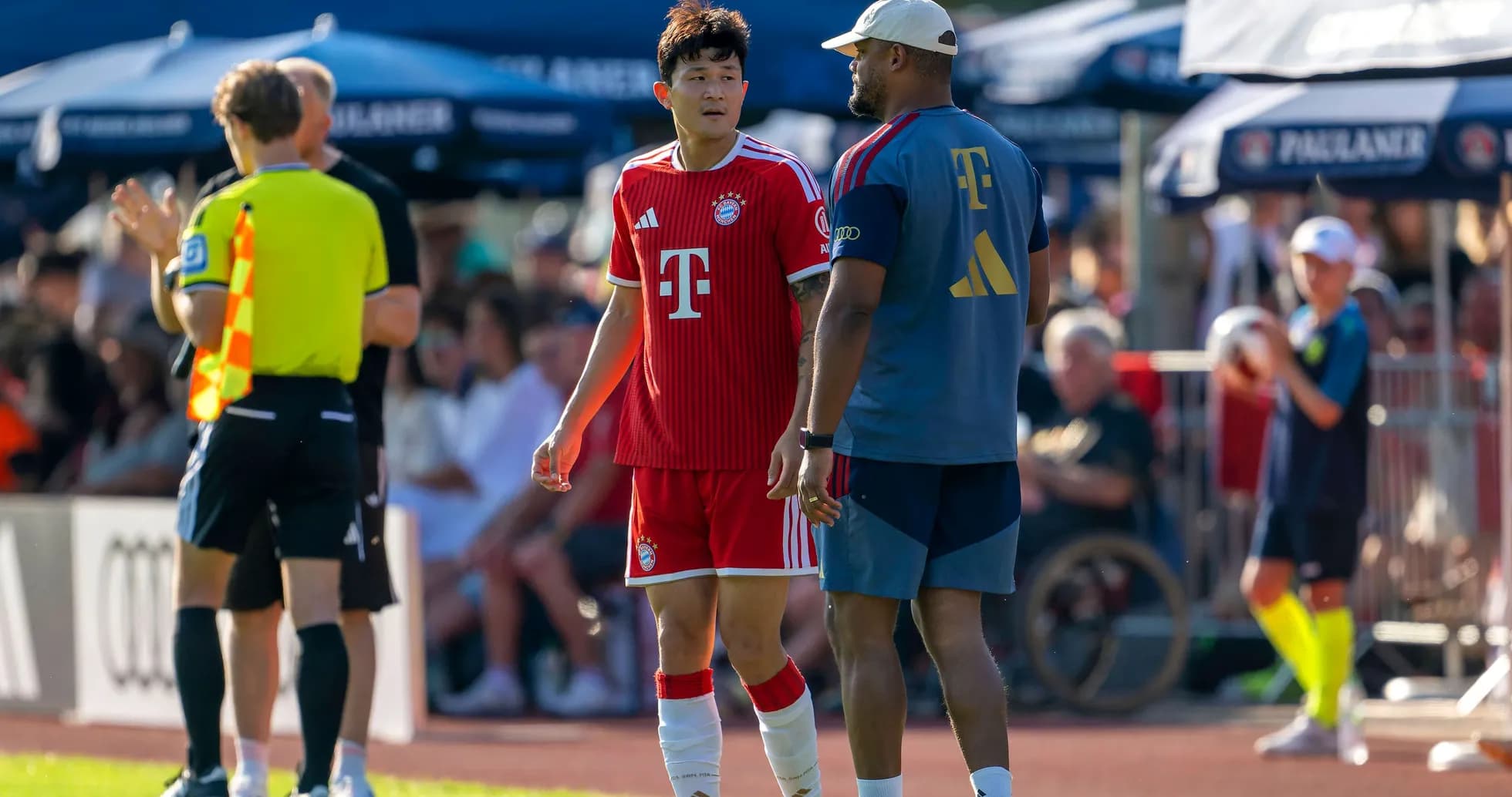 Bayern Munich player conversing with coach on sideline