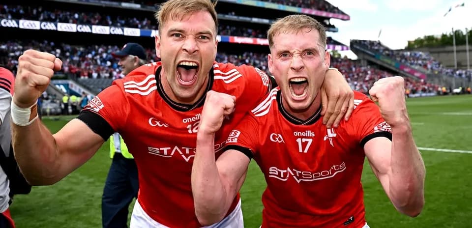 Two players celebrating in red jerseys after match