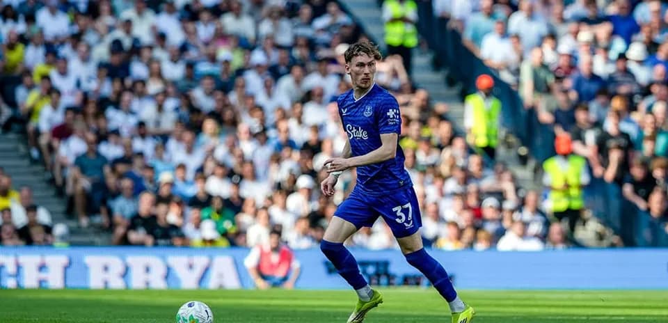Player in blue kit running with ball during match