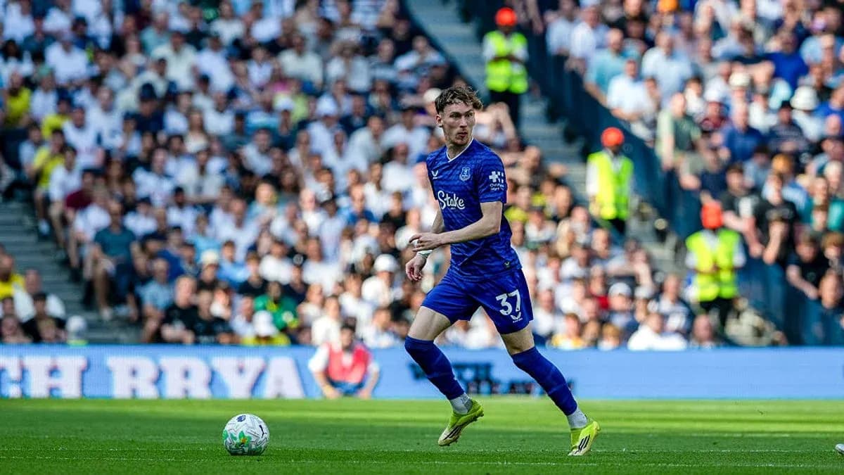 Player in blue kit running with ball during match