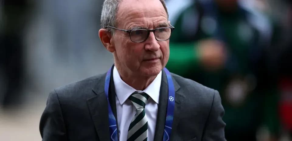 Man in suit walking with UEFA Champions League lanyard