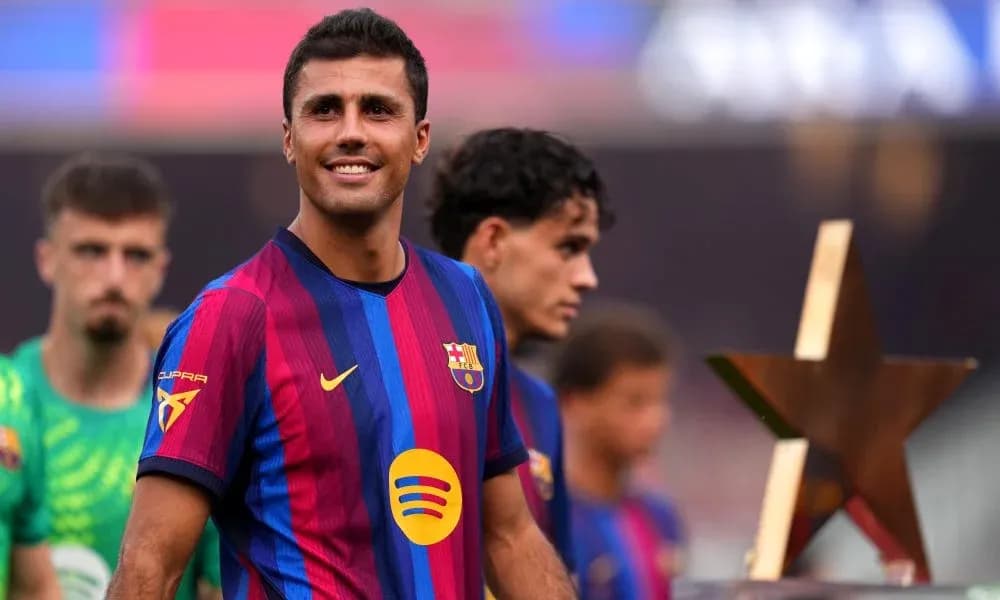 Player smiling while holding trophy on field