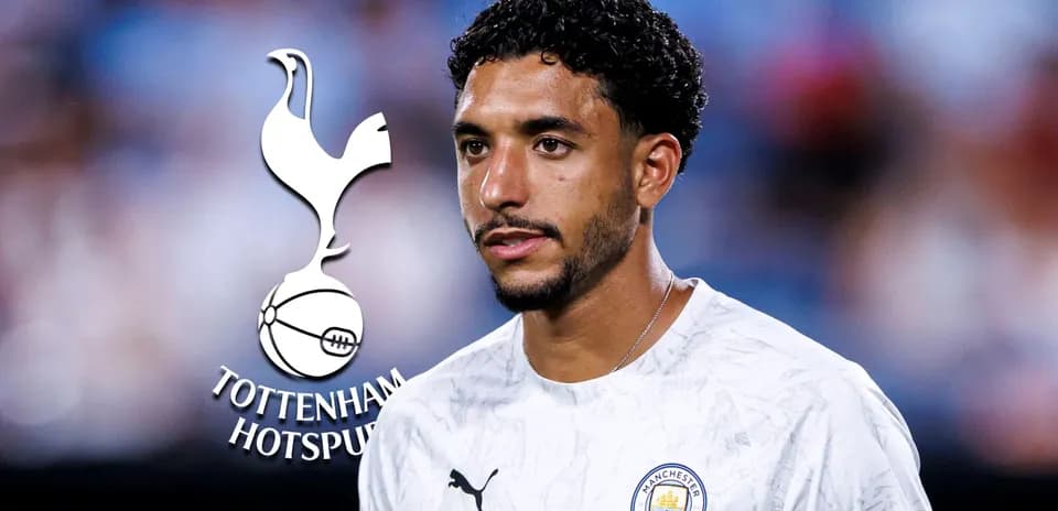 Player in Manchester City shirt near Tottenham logo