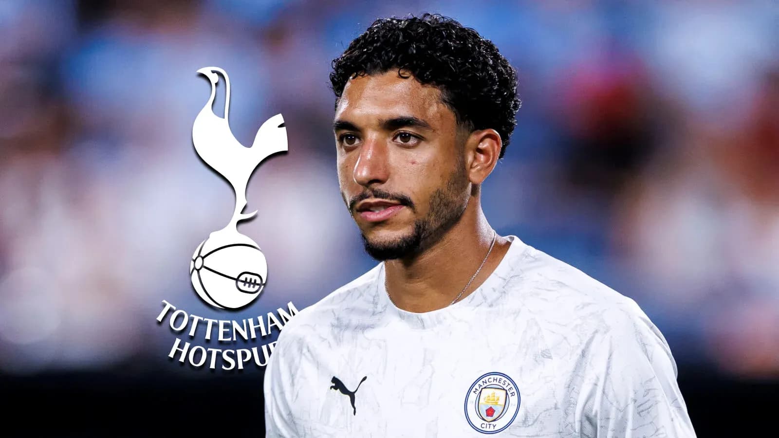 Player in Manchester City shirt near Tottenham logo