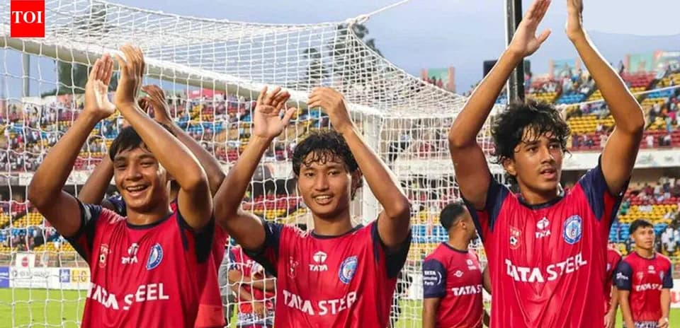 Three players celebrating in front of goal net