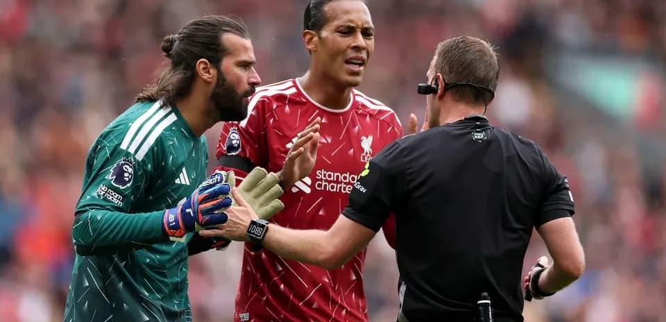 Goalkeeper and defender discussing with the referee