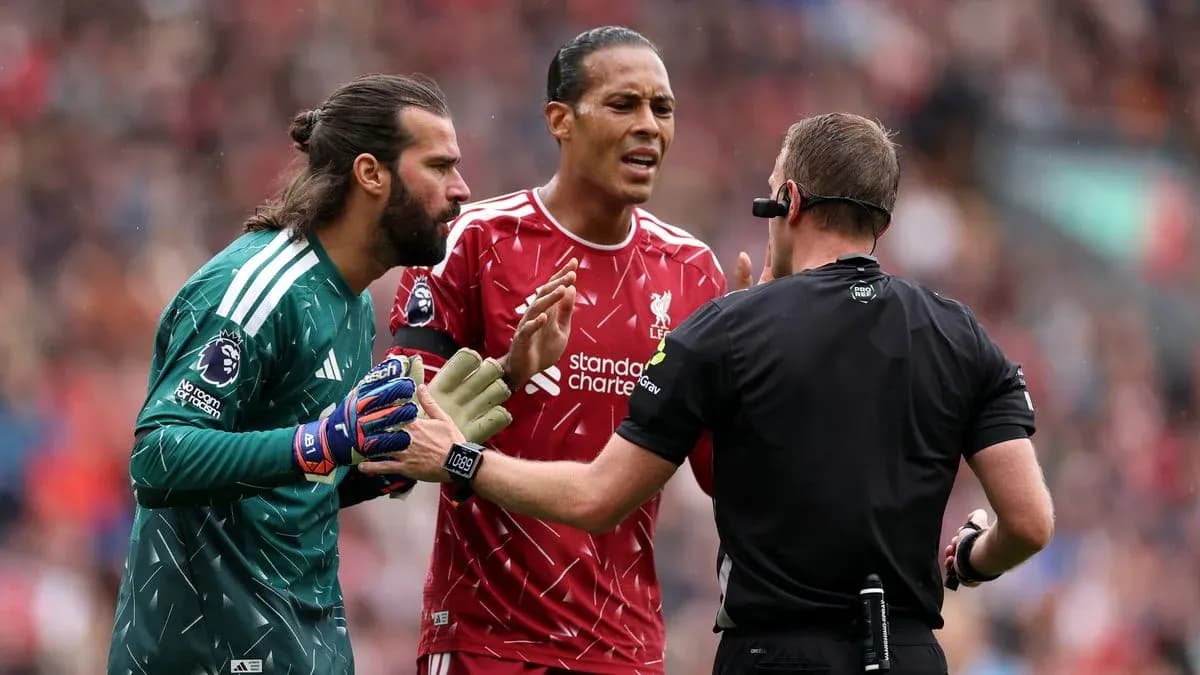 Goalkeeper and defender discussing with the referee