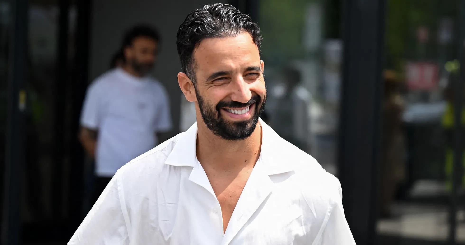 Man smiling while walking outside a building