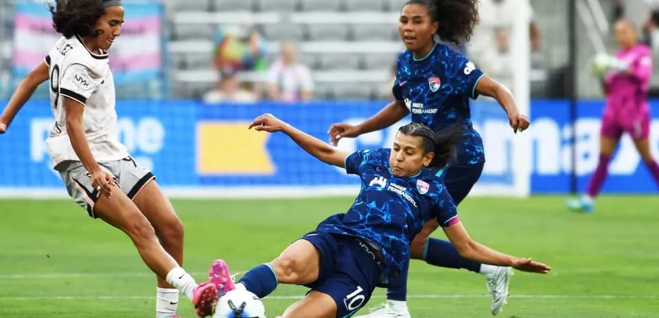 Seattle Reign FC player tackling San Diego Wave player