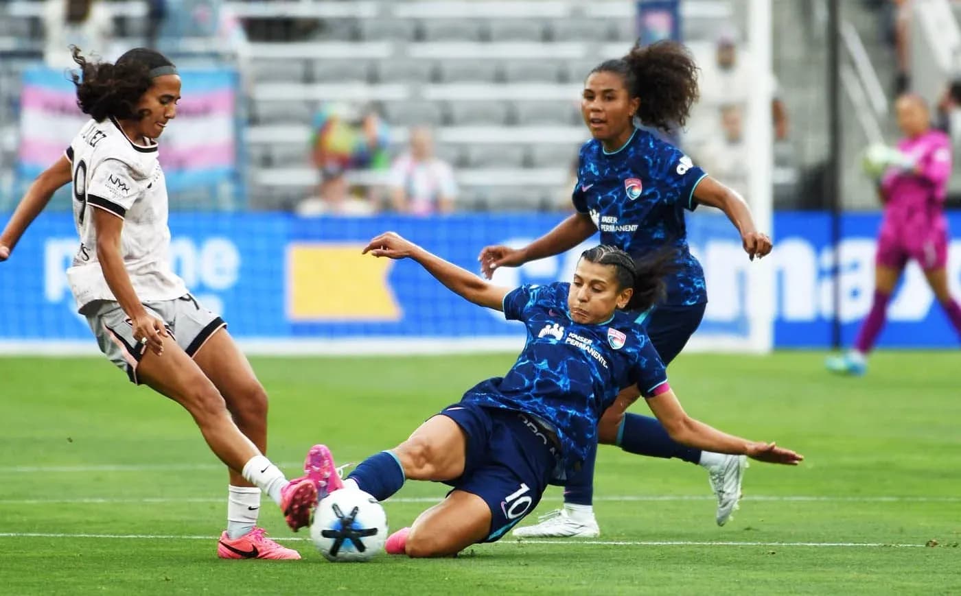 Seattle Reign FC player tackling San Diego Wave player