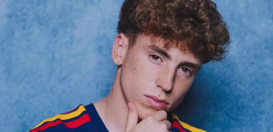 Young man with curly hair posing thoughtfully