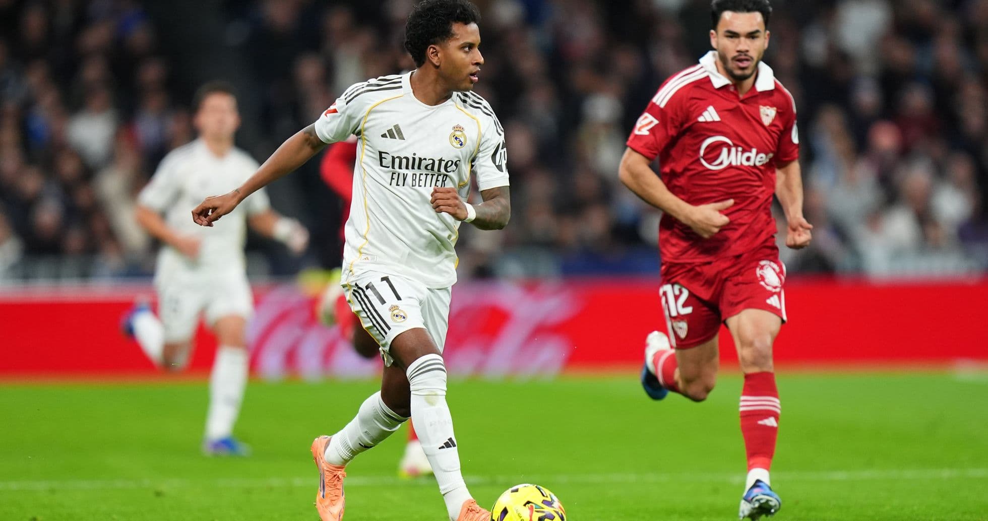 Real Madrid player dribbling past Sevilla opponent