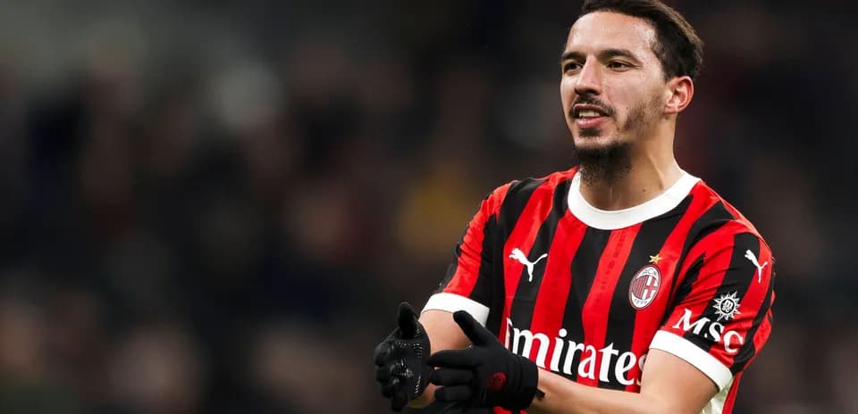 Player in AC Milan jersey gesturing on the field