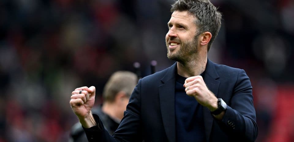 Manager celebrating with clenched fist on pitch