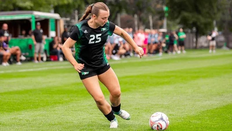Player 25 kicking soccer ball on field