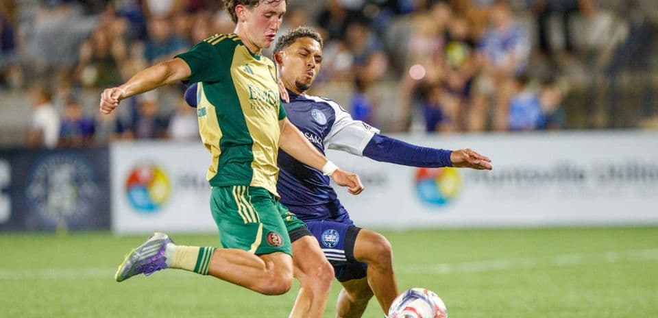 Player tackling opponent during Huntsville City match