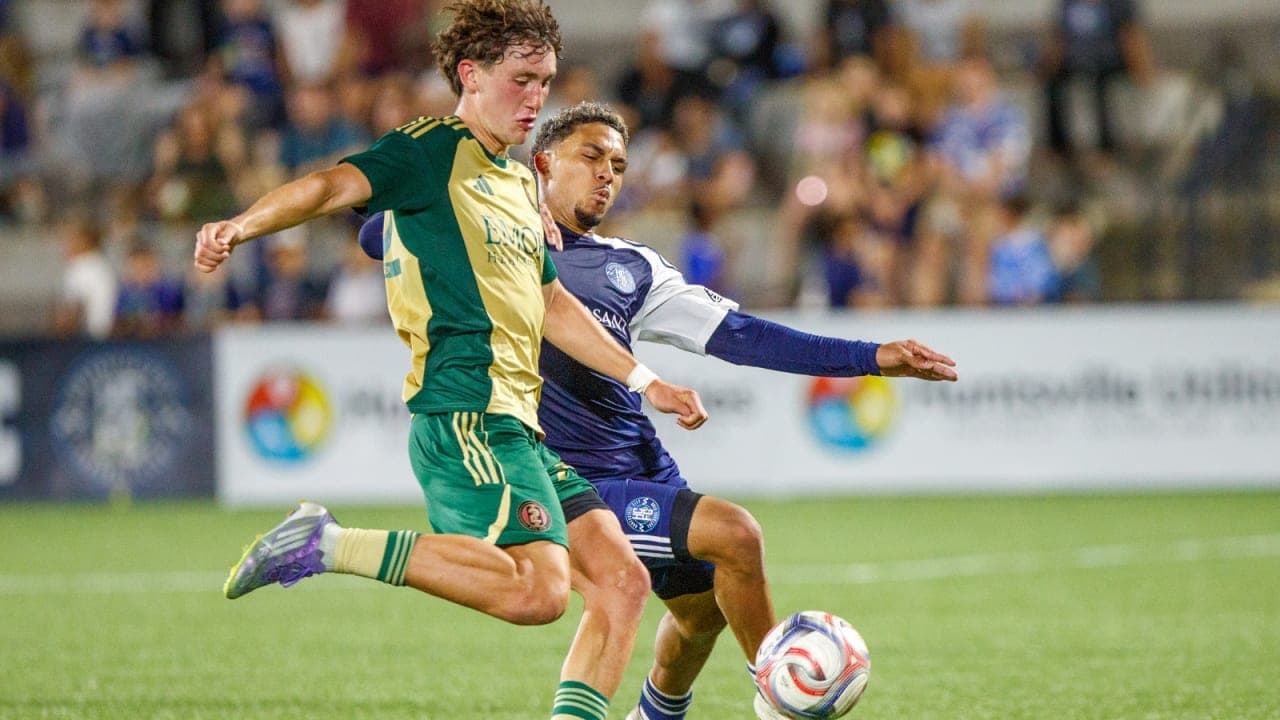 Player tackling opponent during Huntsville City match