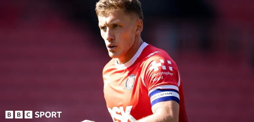 Player in red jersey with captain's armband during match