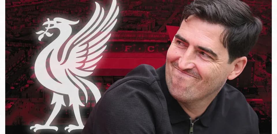 Man smiling with Liverpool logo in background