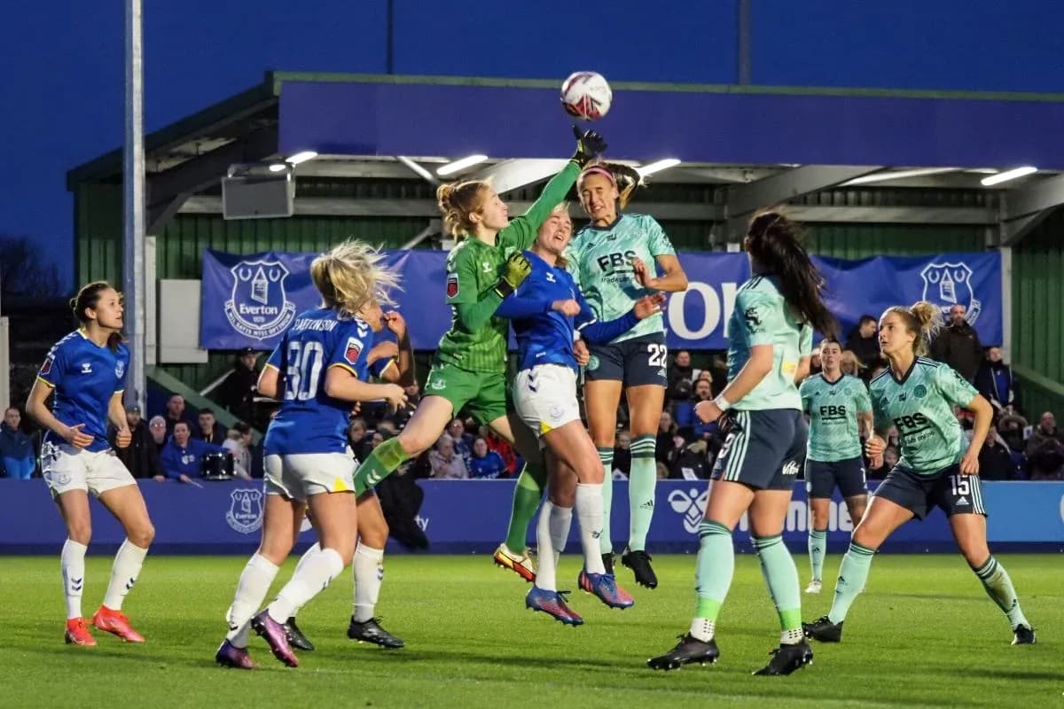 Goalkeeper attempting to catch the ball during match