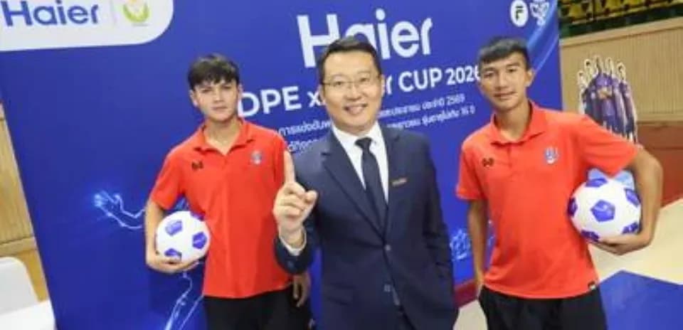 Two players holding soccer balls with event representative