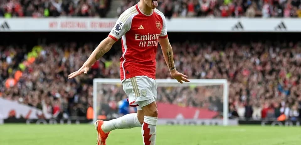 Arsenal player celebrating goal with fans in background