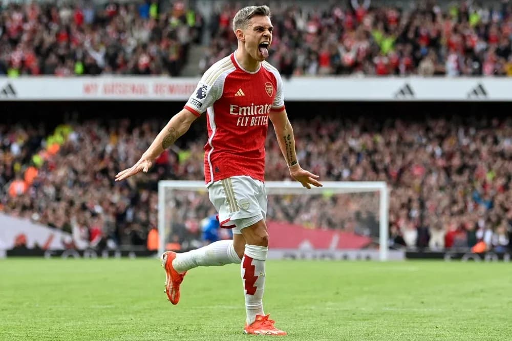 Arsenal player celebrating goal with fans in background