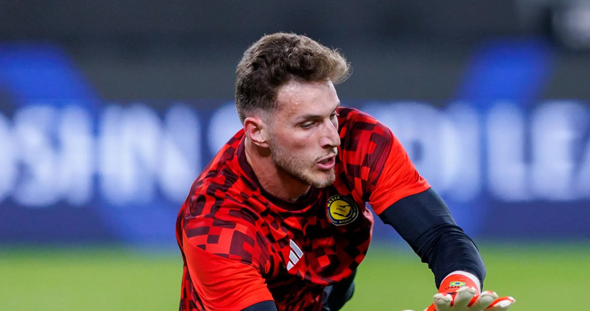 Goalkeeper in red jersey preparing to catch ball