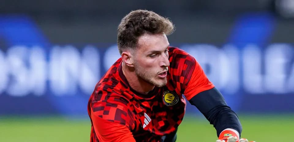 Goalkeeper in red jersey preparing to catch ball