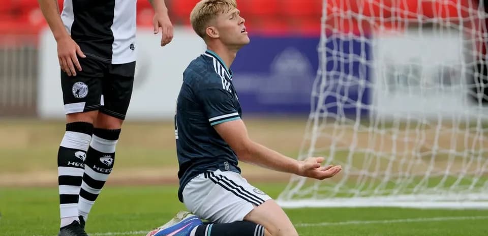 Player kneeling on field with hands raised