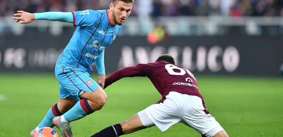 Cagliari player dribbling past Torino defender