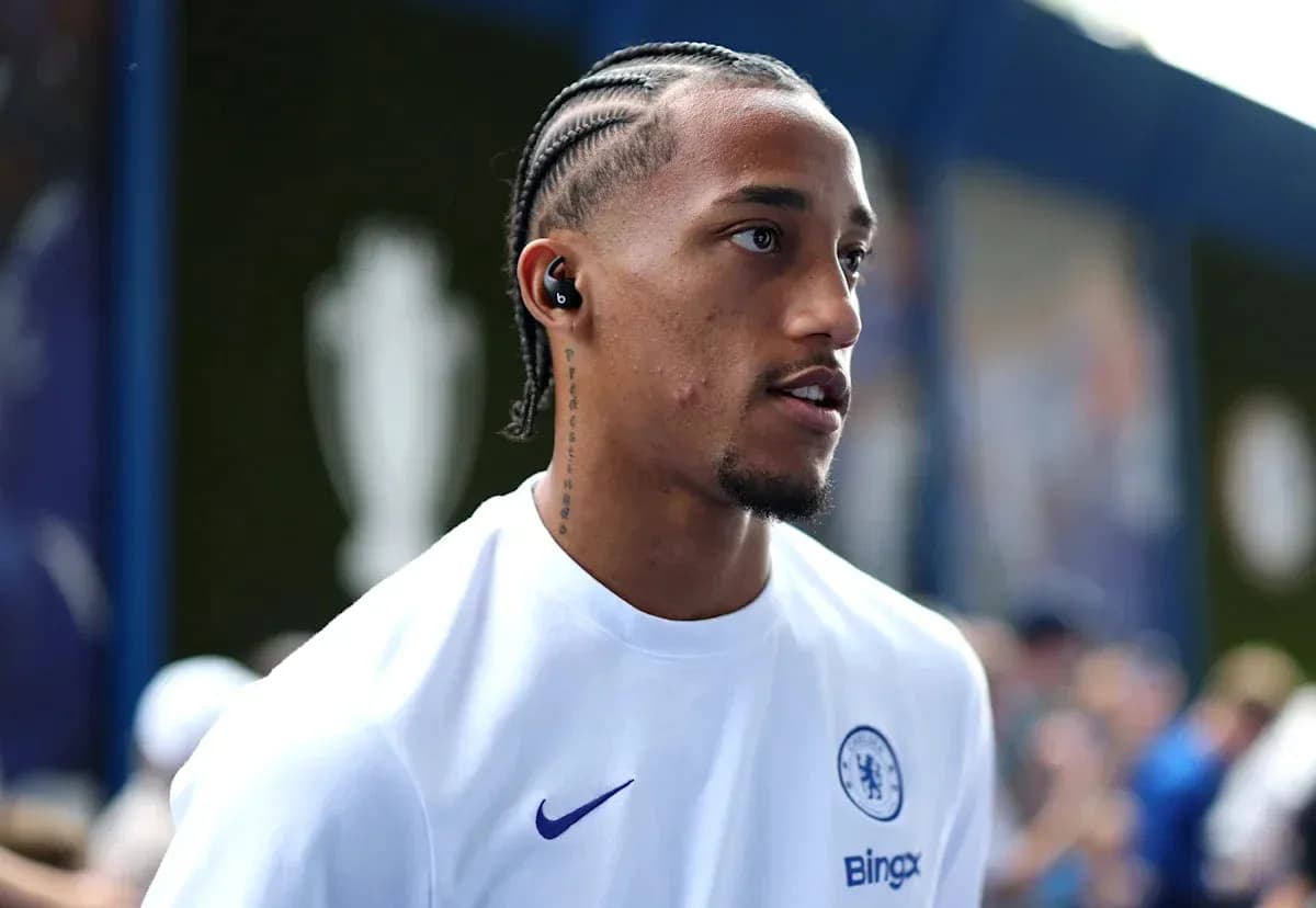 Player wearing Chelsea shirt with earbuds in stadium