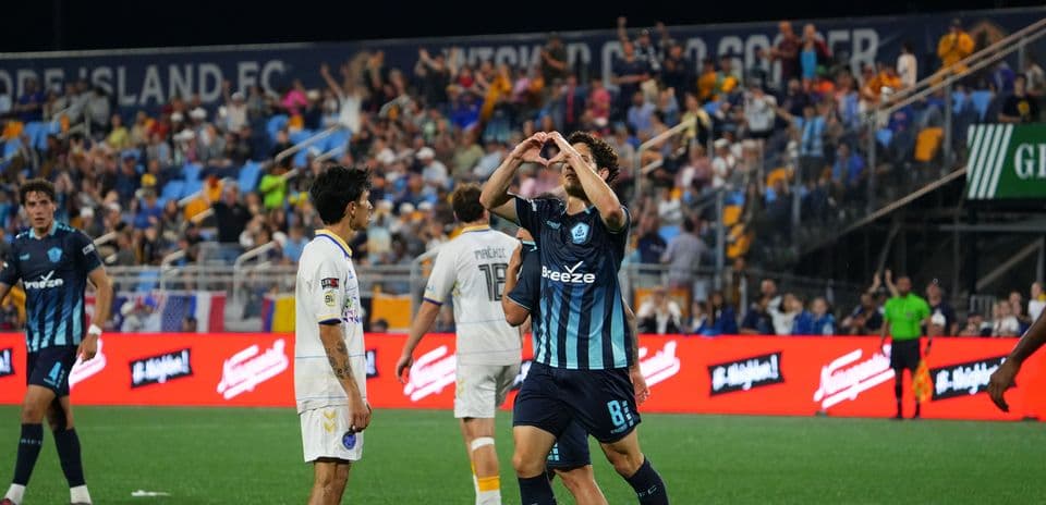 Player celebrating with fans during Rhode Island match
