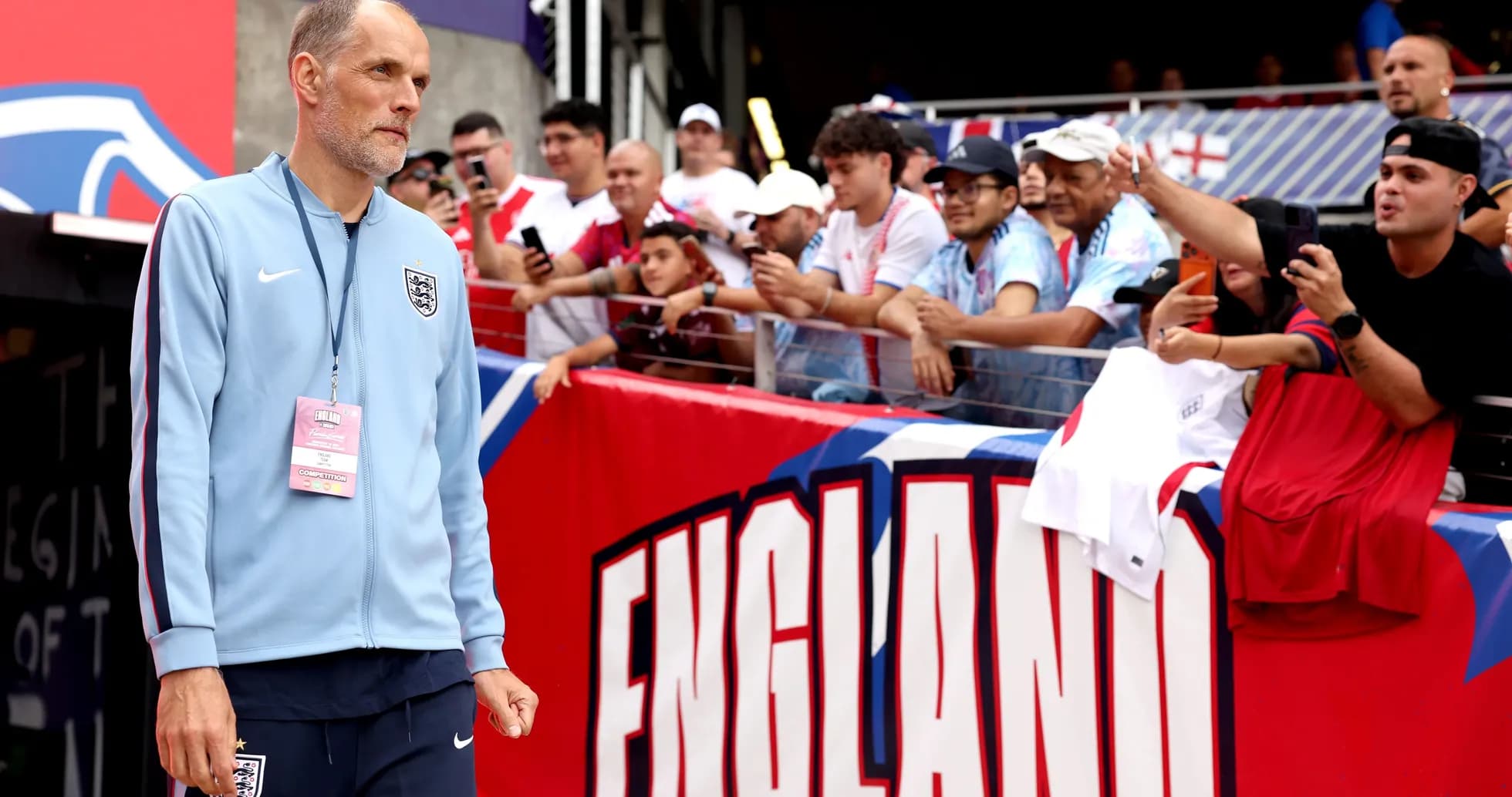 Manager walking past fans at stadium entrance