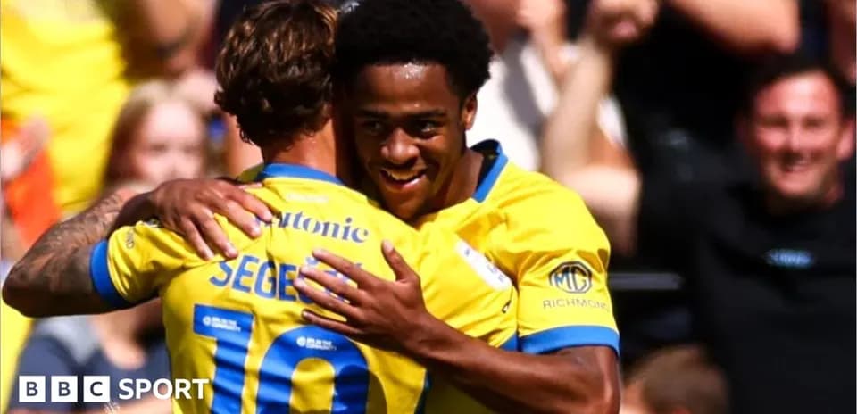Players celebrating a goal with a hug