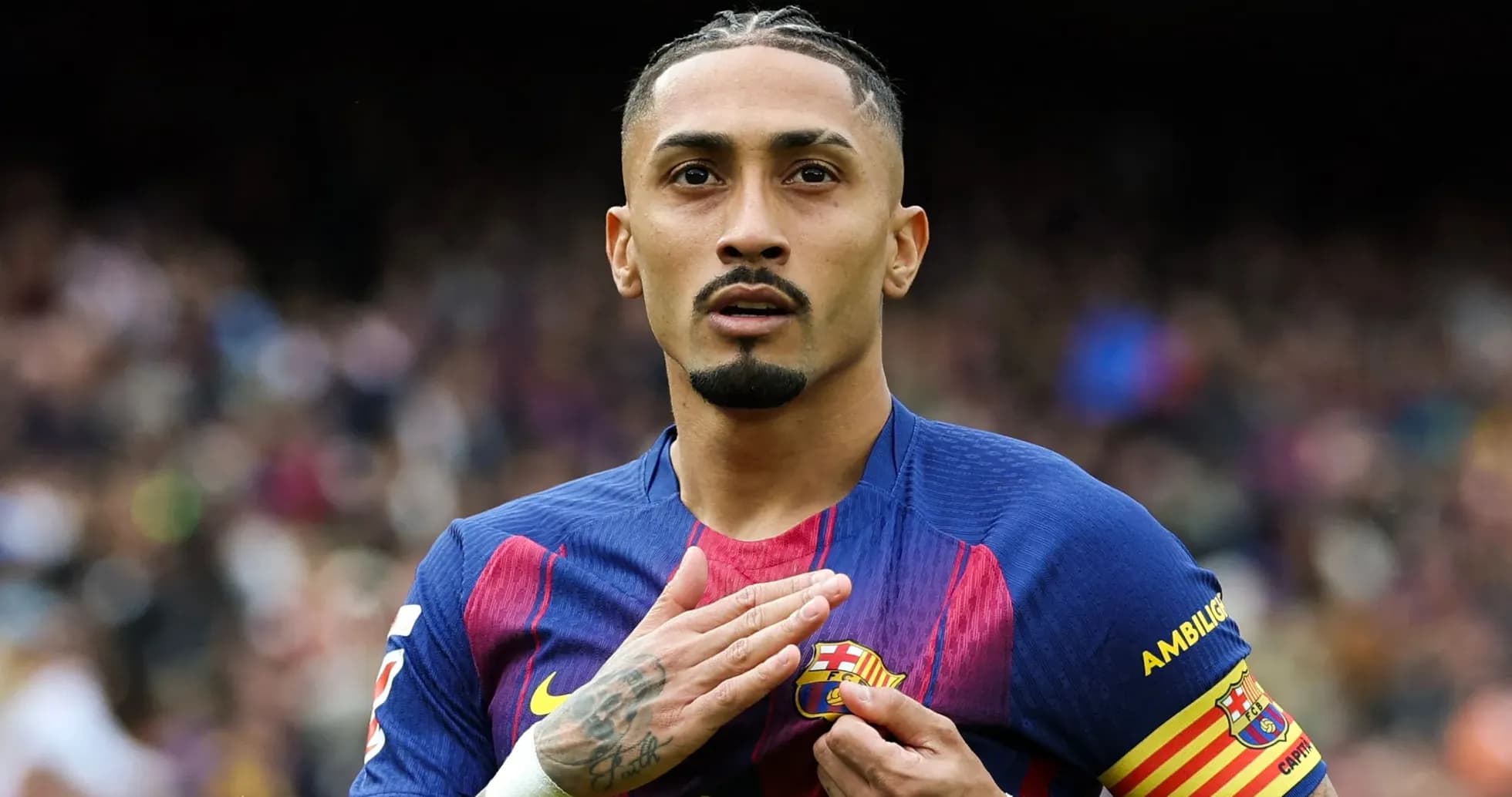 Player gesturing with hand on FC Barcelona badge
