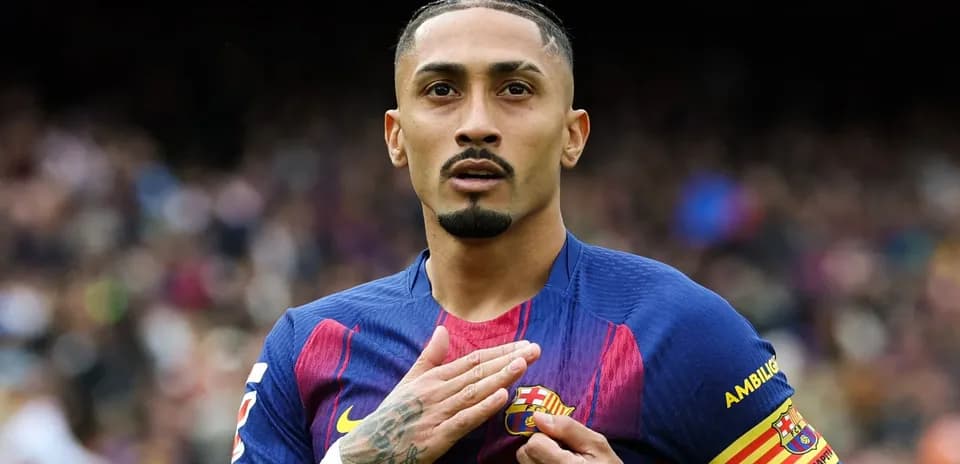 Player gesturing with hand on FC Barcelona badge
